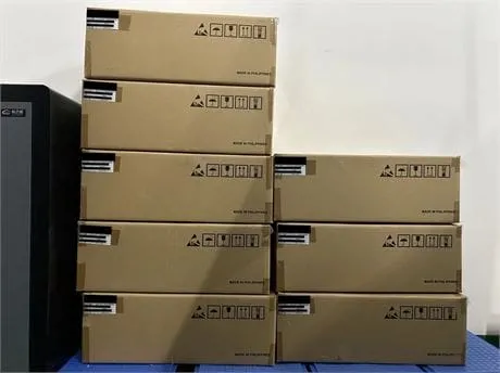 Two stacks of brown cardboard cartons with shipping labels and handling icons on a blue floor beside a gray cabinet