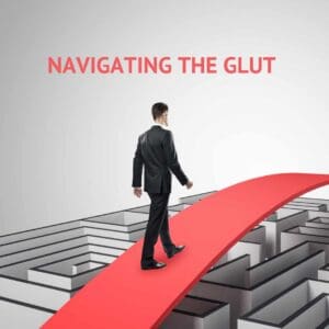 A business man using a red bridge to walk over a maze